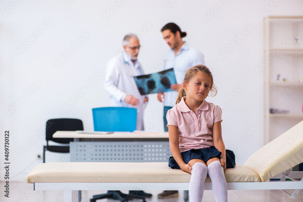 Small girl with her father visiting old male doctor radiologist Small girl with her father visiting old male doctor radiologist
