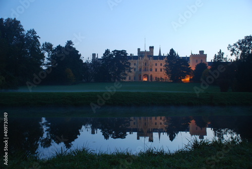 Lednice Chateau reflected in water in evening