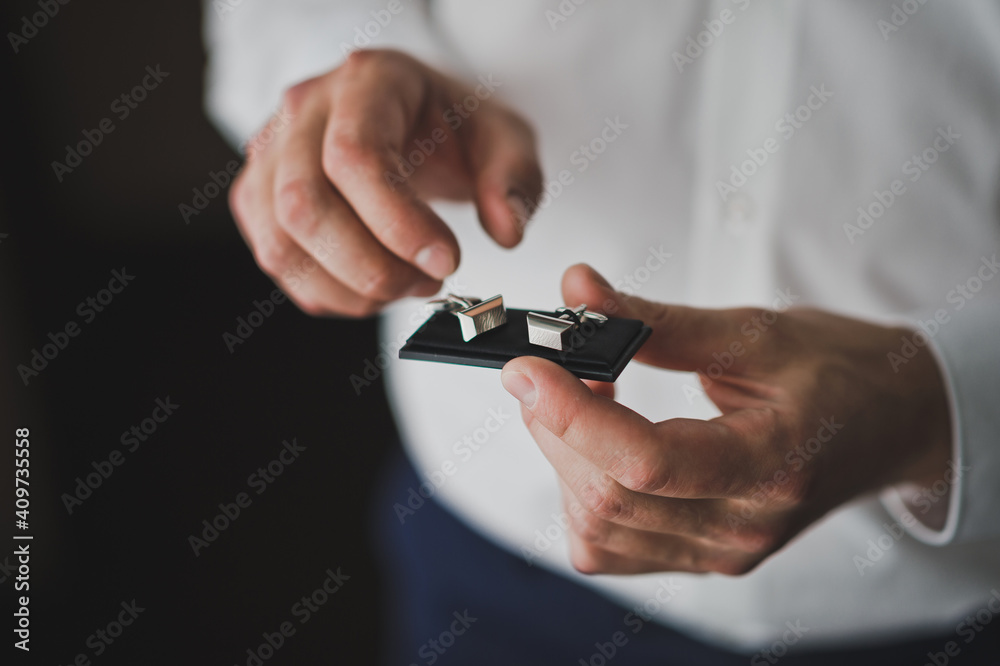 The groom is going to take the shirt cufflinks out of the box 2587.