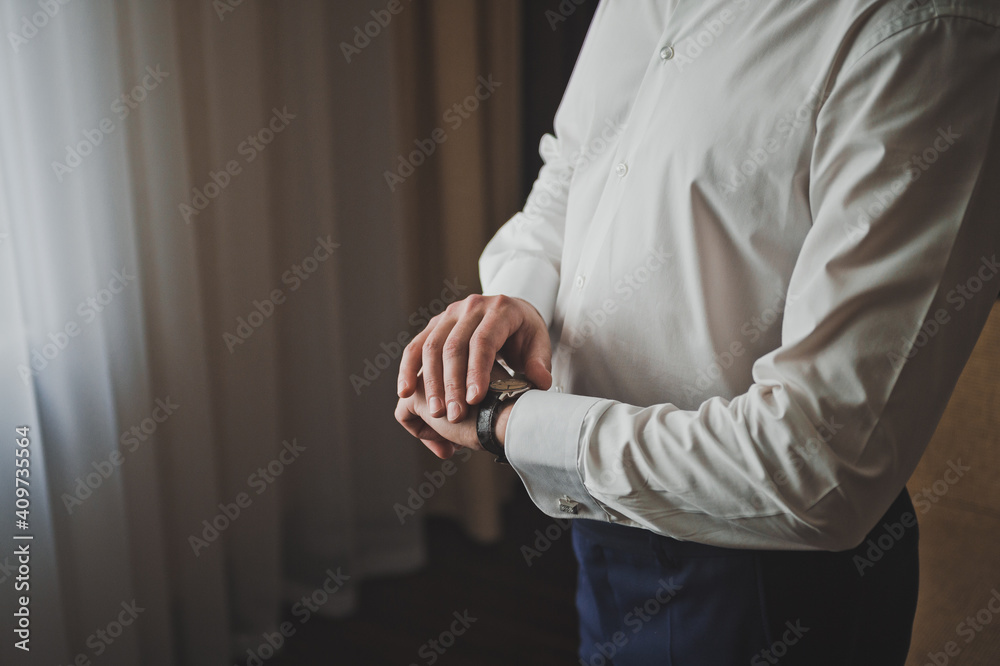 Mens hands are holding on to the wristwatch on their hand 2591. Mens hands are holding on to the wristwatch on their hand 2591.