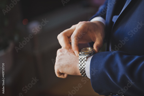 The groom looks at the time on a hand watch 2616.