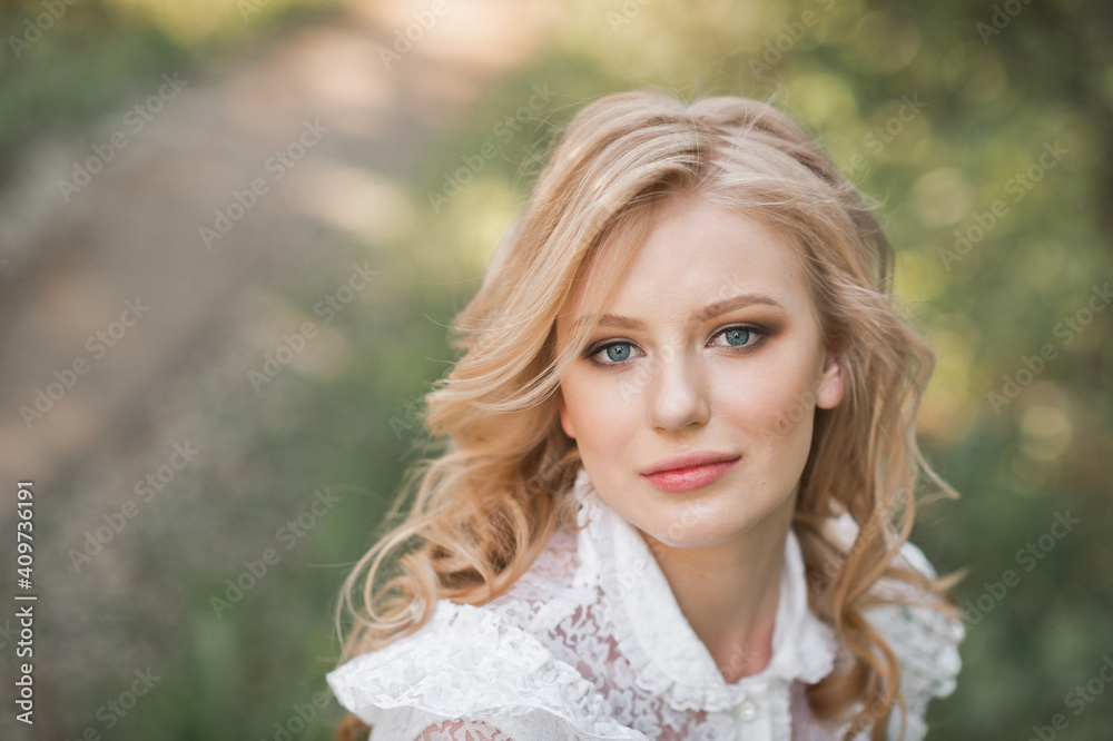 A beautiful portrait of a girl with blue eyes in a white dress in the garden 2695. A beautiful portrait of a girl with blue eyes in a white dress in the garden 2695.