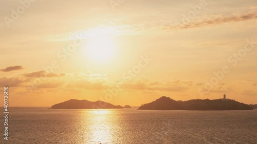 Timelapse with beautiful views of the peaceful ocean at mountainous sunset and clear skies with the setting sun. Sunset video concept. Vacation concept.