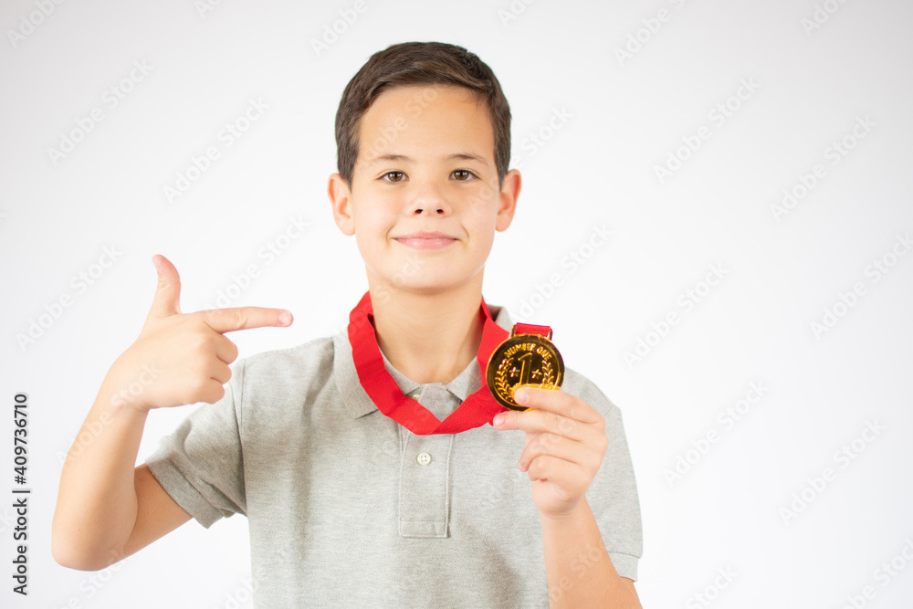 Young boy showing his golden medal over white background. Young boy showing his golden medal over white background.