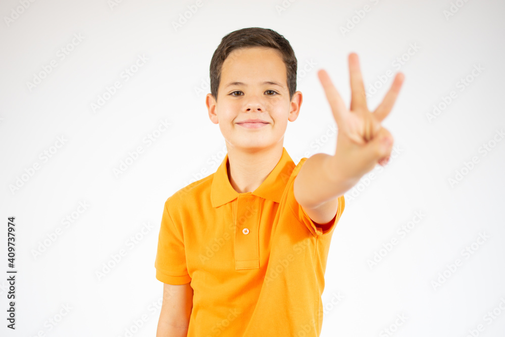 Young little boy kid wearing casual orange t-shirt standing over isolated background showing and pointing up with fingers number three while smiling confident and happy. Young little boy kid wearing casual orange t-shirt standing over isolated background showing and pointing up with fingers number three while smiling confident and happy.