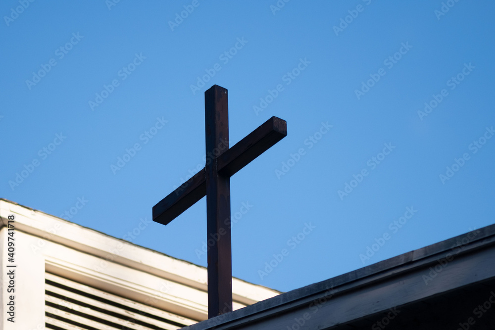 Cross on top of a church against the blue sky with copy-space, religious concept and background
