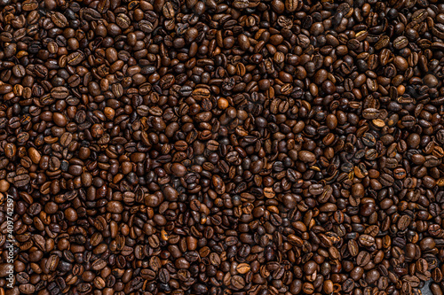 Roasted coffee beans on rustic table. Black background. Top view