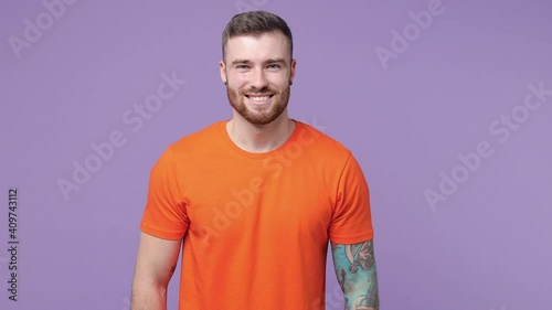 Wallpaper Mural Cheerful laughing bearded tattooed young man 20s years old in orange basic casual t-shirt isolated on purple violet color background studio. People emotions lifestyle concept. Looking camera blinking Torontodigital.ca