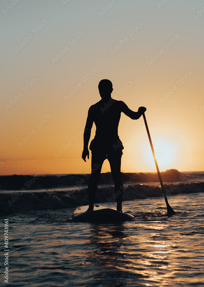 surfer in the sea at sunset