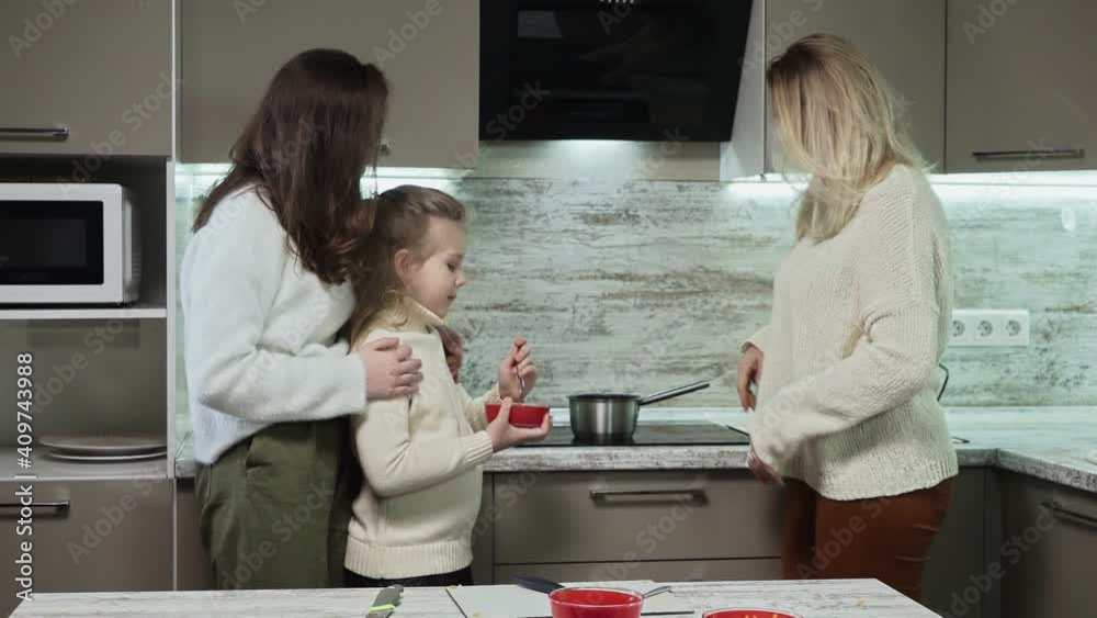 Little girl put salt in pot with potatoes