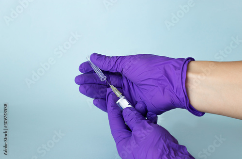 hands in glove holding a syringe