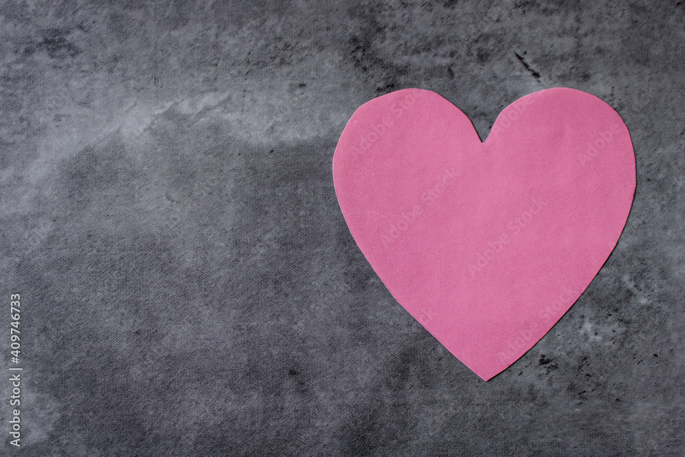 Pink paper heart shape on an abstract background in grey tones. Flat lay with empty space for text. Valentine's Day or love concept Pink paper heart shape on an abstract background in grey tones. Flat lay with empty space for text. Valentine's Day or love concept
