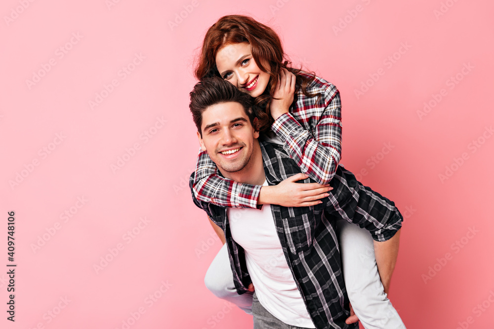Adorable girl embracing husband in valentine's day. Studio shot of couple enjoying date. - obrazy, fototapety, plakaty 