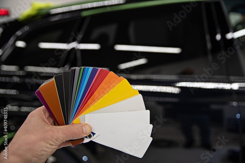 Man choosing color of his car with color sampler. Car foil wrapping colors picker photo