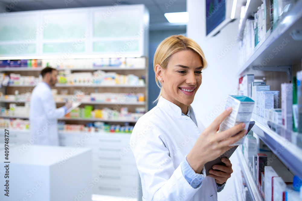 Woman pharmacist holding medicine in pharmacy shop. Healthcare and medicine concept.