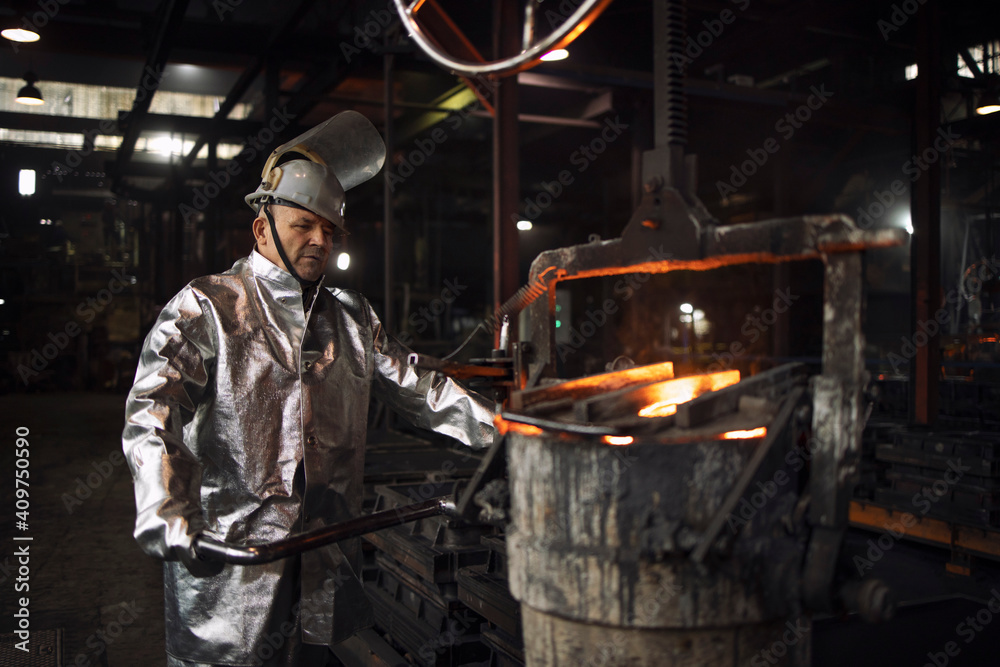 Foundry worker ready to pour liquid iron into molds. Casting and steel production. Foundry worker ready to pour liquid iron into molds. Casting and steel production.