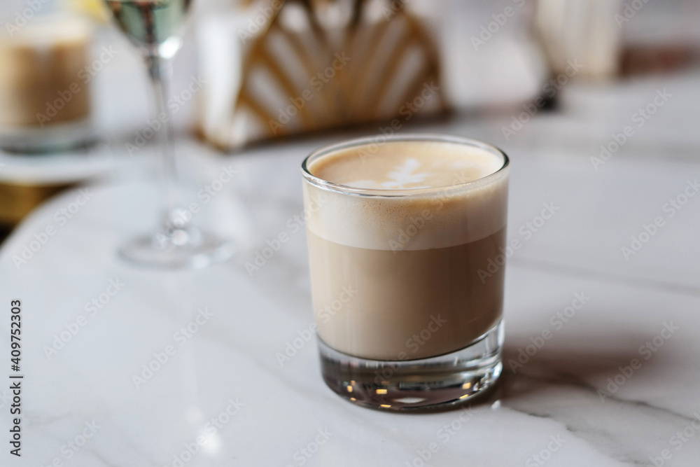 A glass of cappuccino on the table in a cafe A glass of cappuccino on the table in a cafe