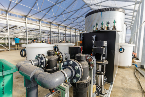 Large industrial water treatment and boiler system in a greenhouse with many pipes and valves