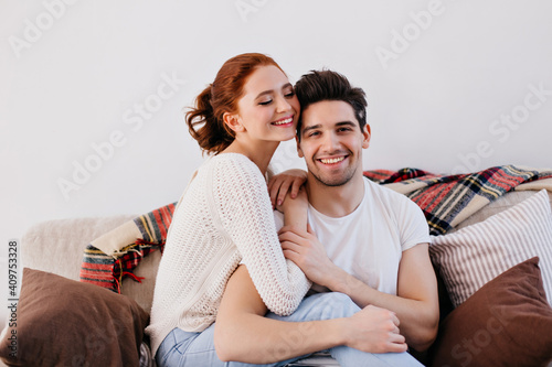 Wife and husband sitting on sofa. Romantic couple having fun at home.
