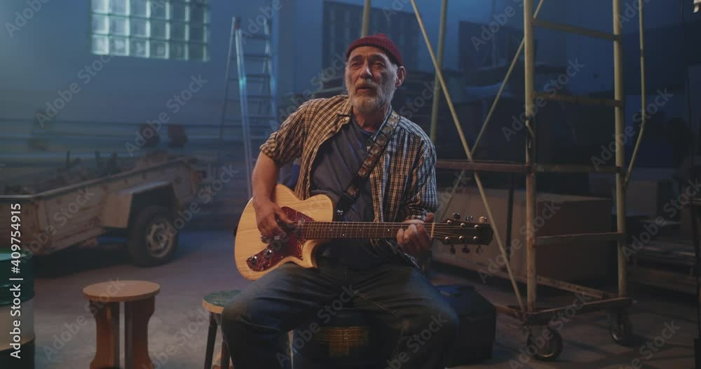 Bearded guitarist singing hearty song in garage Bearded guitarist singing hearty song in garage