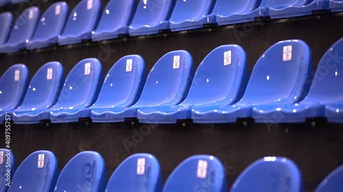 Wet blue chairs on the tribune of a football stadium under the rain. Place for spectators photo