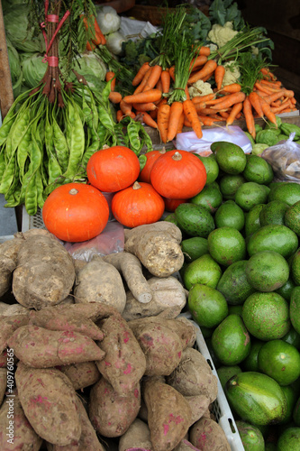 Kinds of vegetables and fruit in a traditional shop. There are carrots  bitter beans  pumpkin  yams  avocados. Focus Selected
