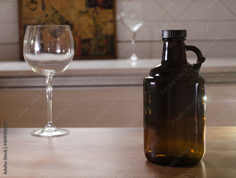 Growler bottle for craft beer and empty glass on a counter. Growler bottle for craft beer and empty glass on a counter.