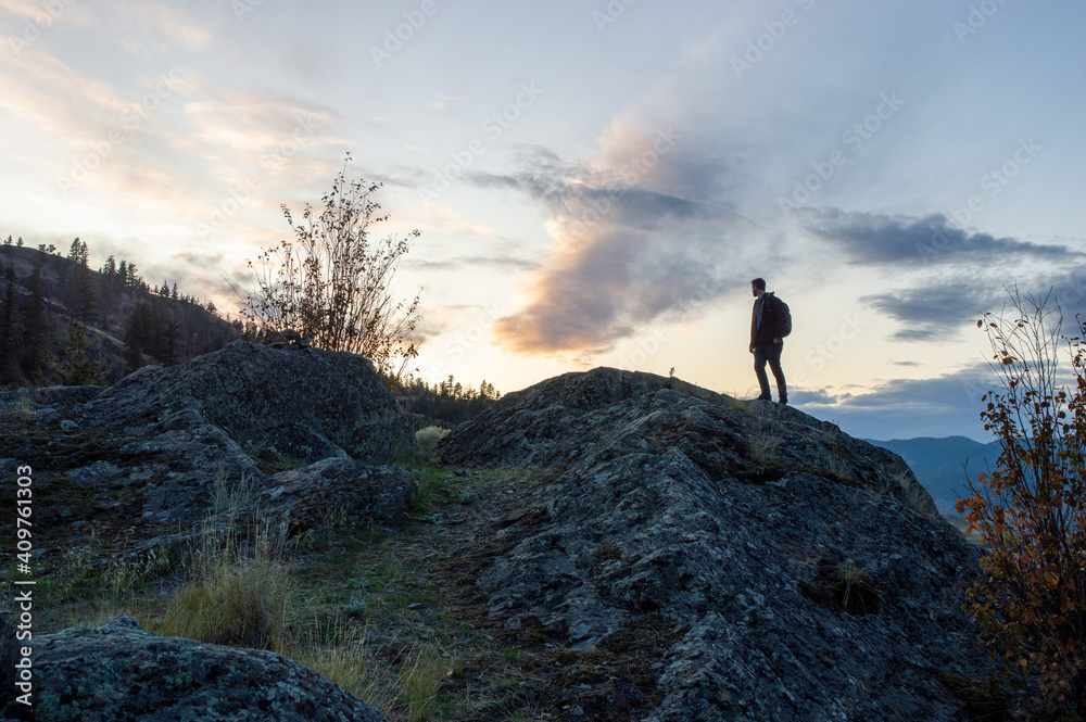 Silhouette of person on hill top during sunset