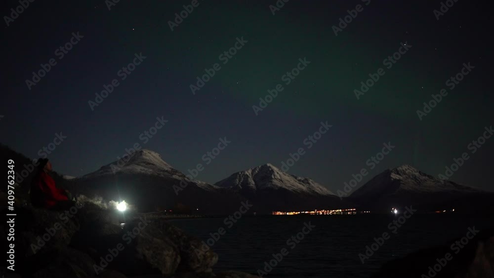 Hiker Watching Aurora Borealis Over Mountains Hiker Watching Aurora Borealis Over Mountains