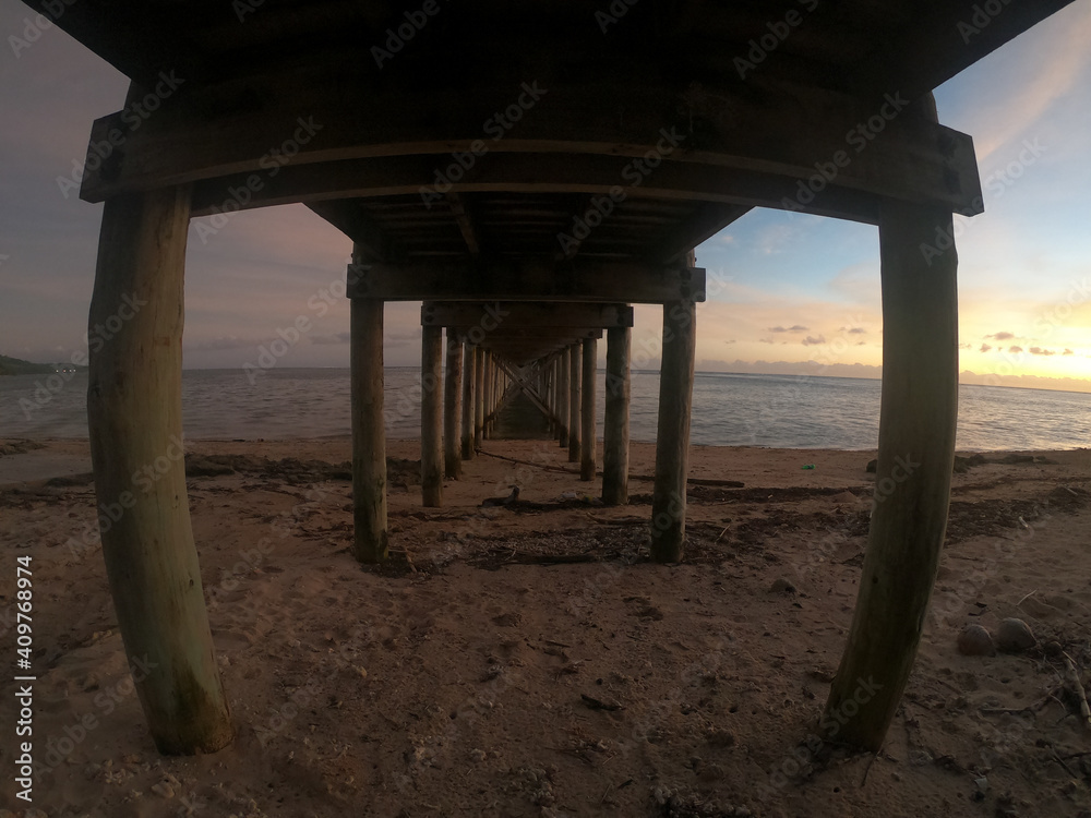 under the pier at sunset