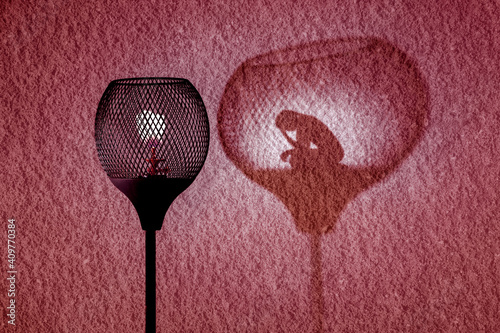 Gaslight with silhouette of woman in shadow cast by the lamp on wall, Gaslighting abuse by coercive control concept illustration photo