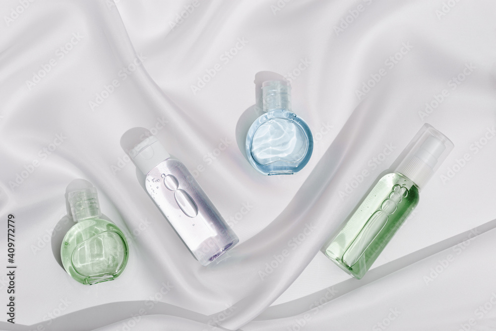Cosmetic product in transparent plastic bottle with beautiful shadows on white silk cloth texture background. Cosmetic product in transparent plastic bottle with beautiful shadows on white silk cloth texture background.