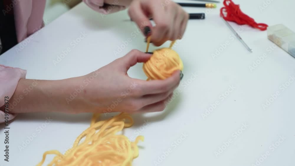 Close up of woman wrapping a ball of yellow thread Close up of woman wrapping a ball of yellow thread