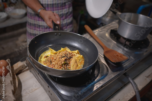 preparing "egg wrapped basil fried rice" at the kitchen on the street, street food