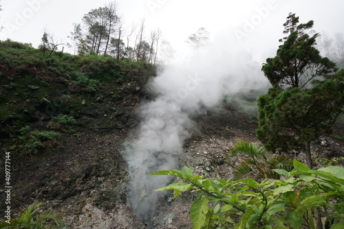 A view of white smoke coming out of one of the craters in the Gedong Songo Temple area, near a hot spring. With a natural background