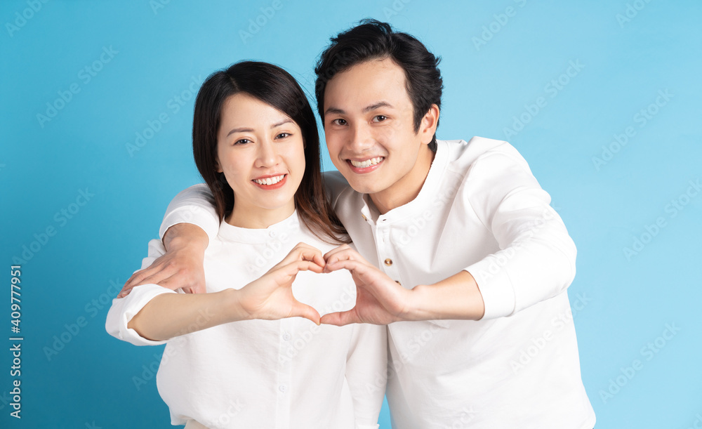 Portrait of young couple standing posing on blue background Portrait of young couple standing posing on blue background