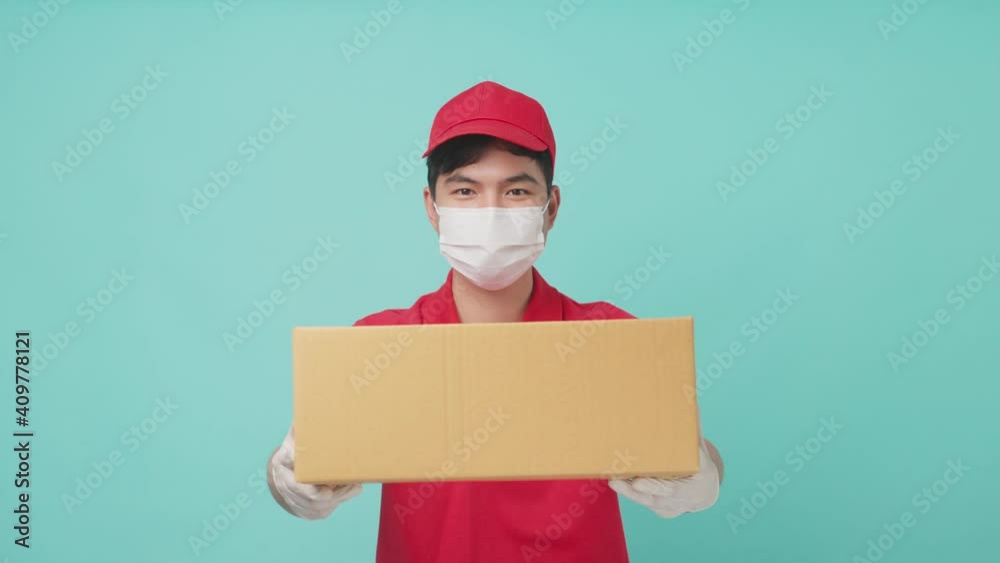 Portrait of Asian delivery man wearing face mask handing box of parcel Portrait of Asian delivery man wearing face mask handing box of parcel