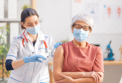 Doctor vaccinating a senior woman