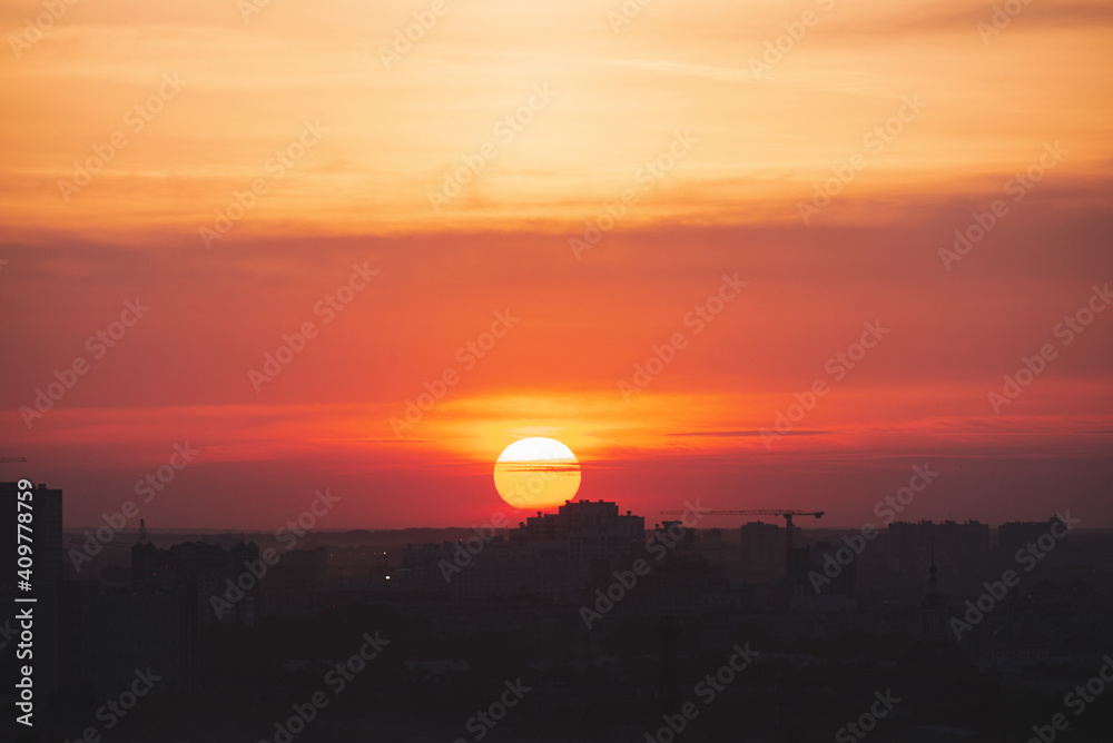 Beautiful orange sunset over the city of Ryazan in summer. Sunrise over the city in the fog in summer