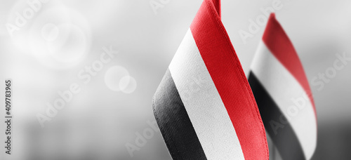 Small national flags of the Yemen on a light blurry background