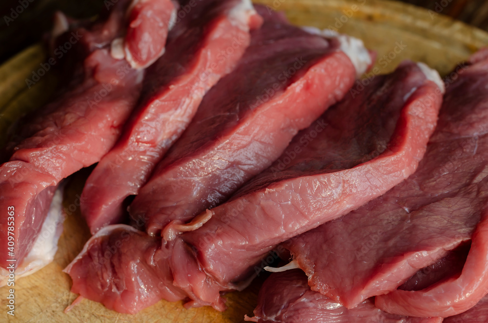 Appetizing red fresh veal, sliced into raw thin beef steaks. Appetizing red fresh veal, sliced into raw thin beef steaks.