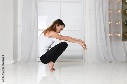 Woman sits squatting in a pose for sports
