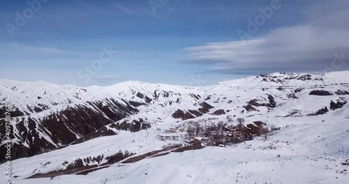 Beautiful little village in the middle of mountains in winter full of snow in highlands. cloudy sky in the wild nature of Iran. travel to Iran hiking in outdoor activity to visit the starry dark sky. photo