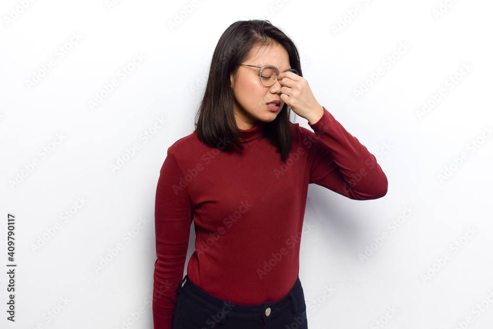 Headache with hand on nose gesture concept of Young beautiful asian women dress red shirt isolated on white background Headache with hand on nose gesture concept of Young beautiful asian women dress red shirt isolated on white background