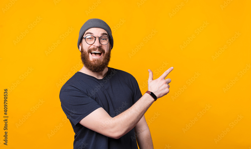 A surprised man is pointing at a free space and is looking at the camera . A surprised man is pointing at a free space and is looking at the camera .