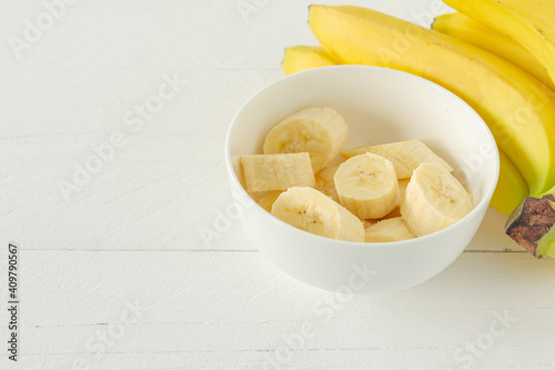 Ripe bananas cut in white bowl for eating. Healthy snack or breakfast concept