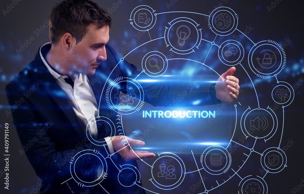 Business, Technology, Internet and network concept. Young businessman working on a virtual screen of the future and sees the inscription: Introduction Business, Technology, Internet and network concept. Young businessman working on a virtual screen of the future and sees the inscription: Introduction