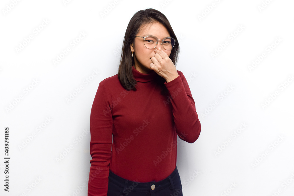 Smelling something stinky and disgusting of Young beautiful asian women dress red shirt isolated on white background Smelling something stinky and disgusting of Young beautiful asian women dress red shirt isolated on white background
