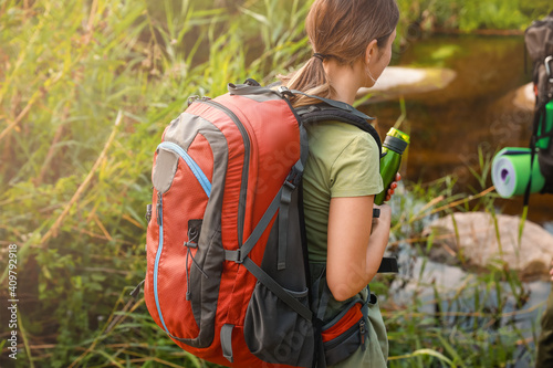 Young female tourist near river in countryside