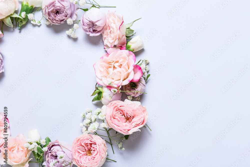 Frame made of beautiful flowers on light background